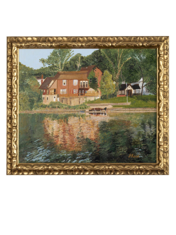 Framed painting of houses by a lake.